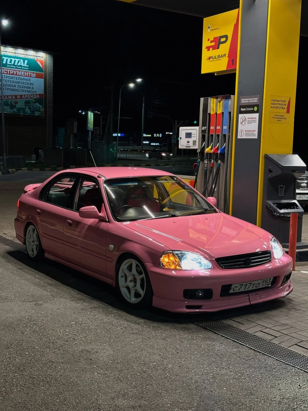 Chiếc Honda Civic độ mâm trắng cổ điển màu hồng tại cây xăng đêm