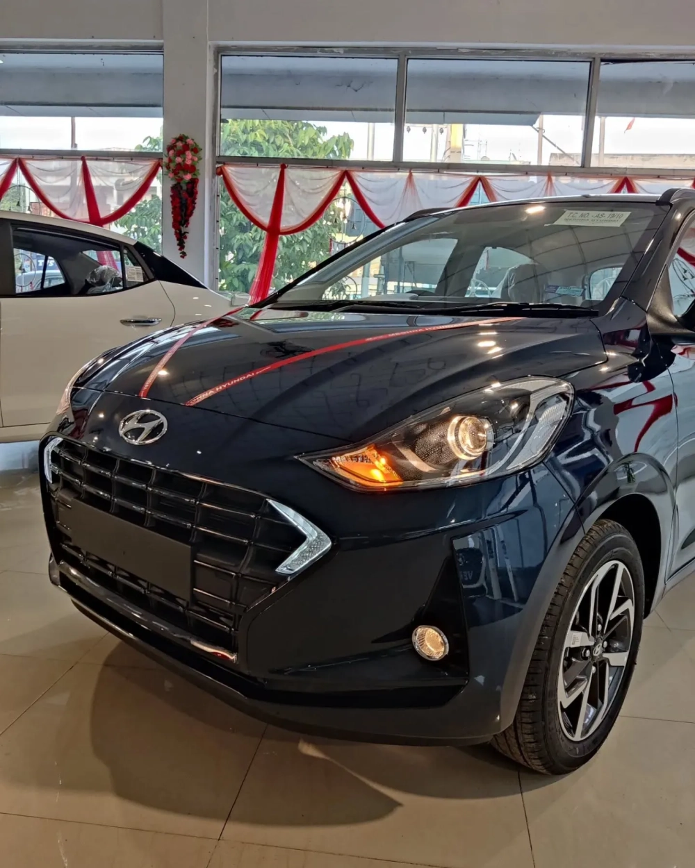 Cận cảnh đầu xe i10 độ mâm đúc hợp kim tại showroom hiện đại