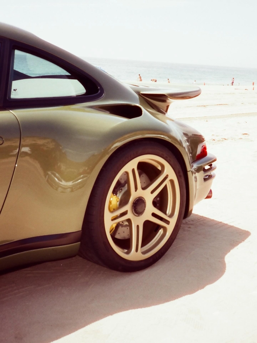 Cận cảnh mâm 5 chấu vàng đồng trên xe thể thao xanh