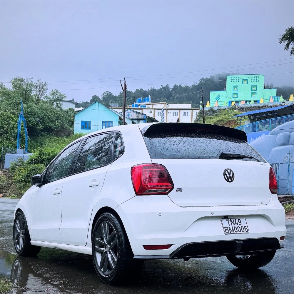 Xe Volkswagen Polo trắng độ mâm lồi đa chấu dưới trời mưa bay