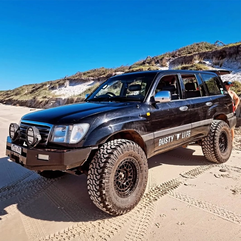 SUV màu đen độ mâm Offroad lưới đen chạy trên bãi cát biển