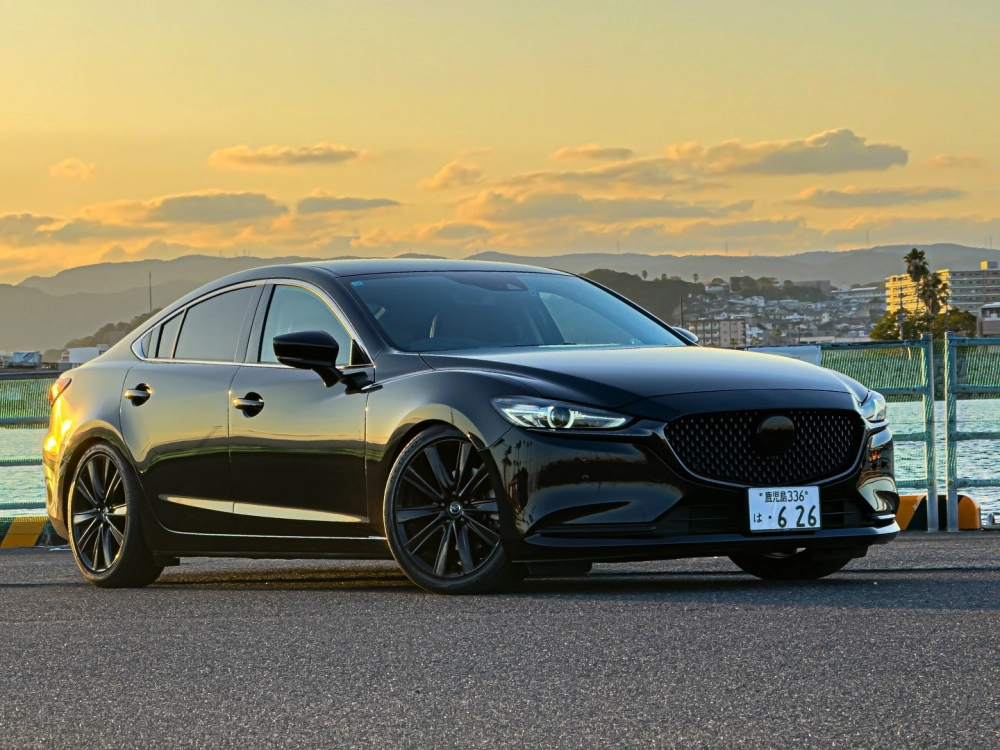 Xe sedan đen Mazda 6 độ mâm đen đa chấu dưới ánh hoàng hôn